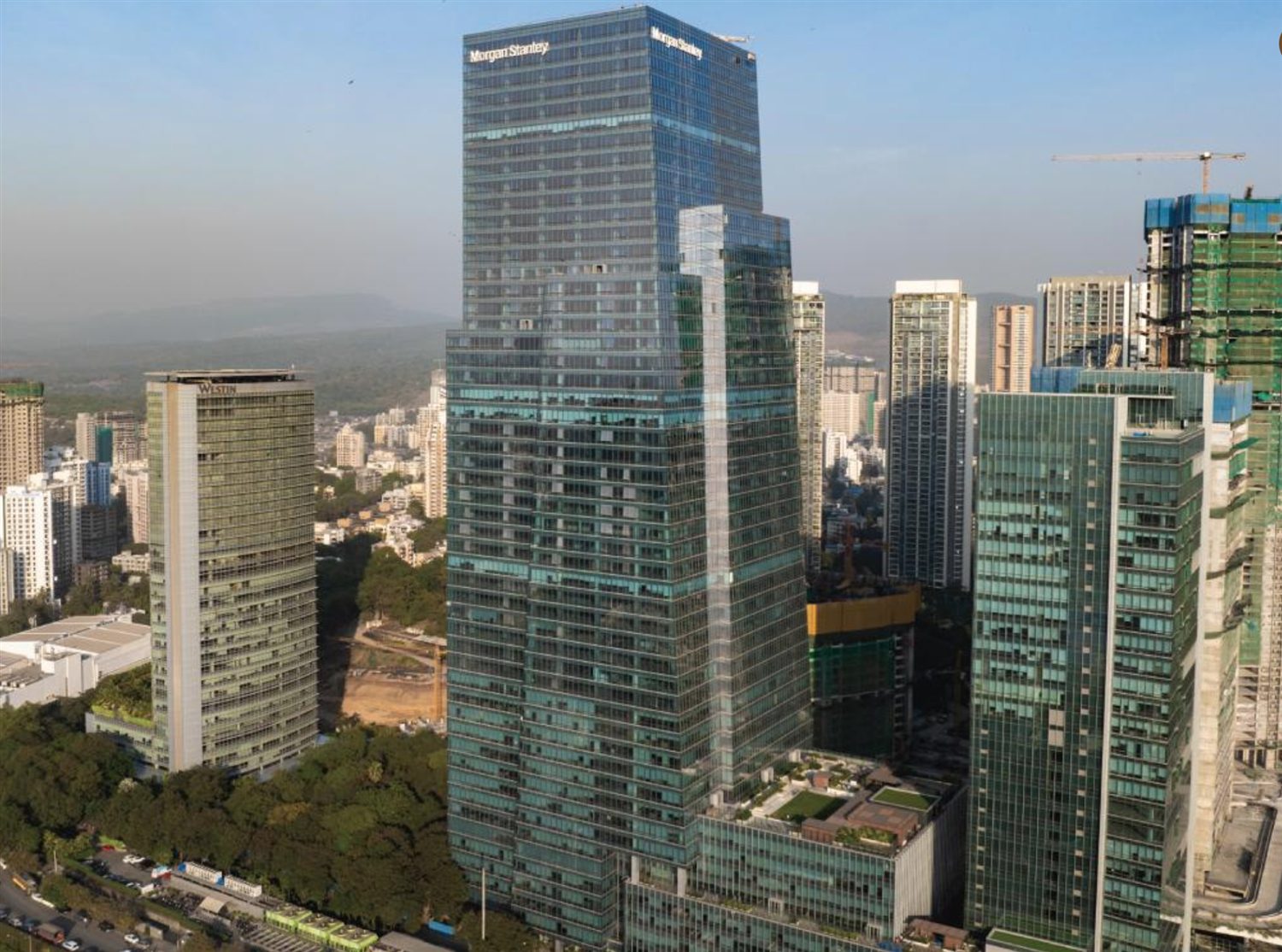 High-rise towers under construction beside completed skyscrapers